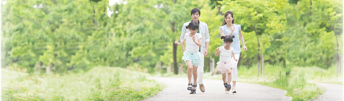自然の中に、母、父、子供二人の四人家族がいて、子供たちがはしゃいでいる写真